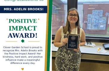 Mrs. Adelin Brooks smiles while holding her CGS Positive Impact Award.